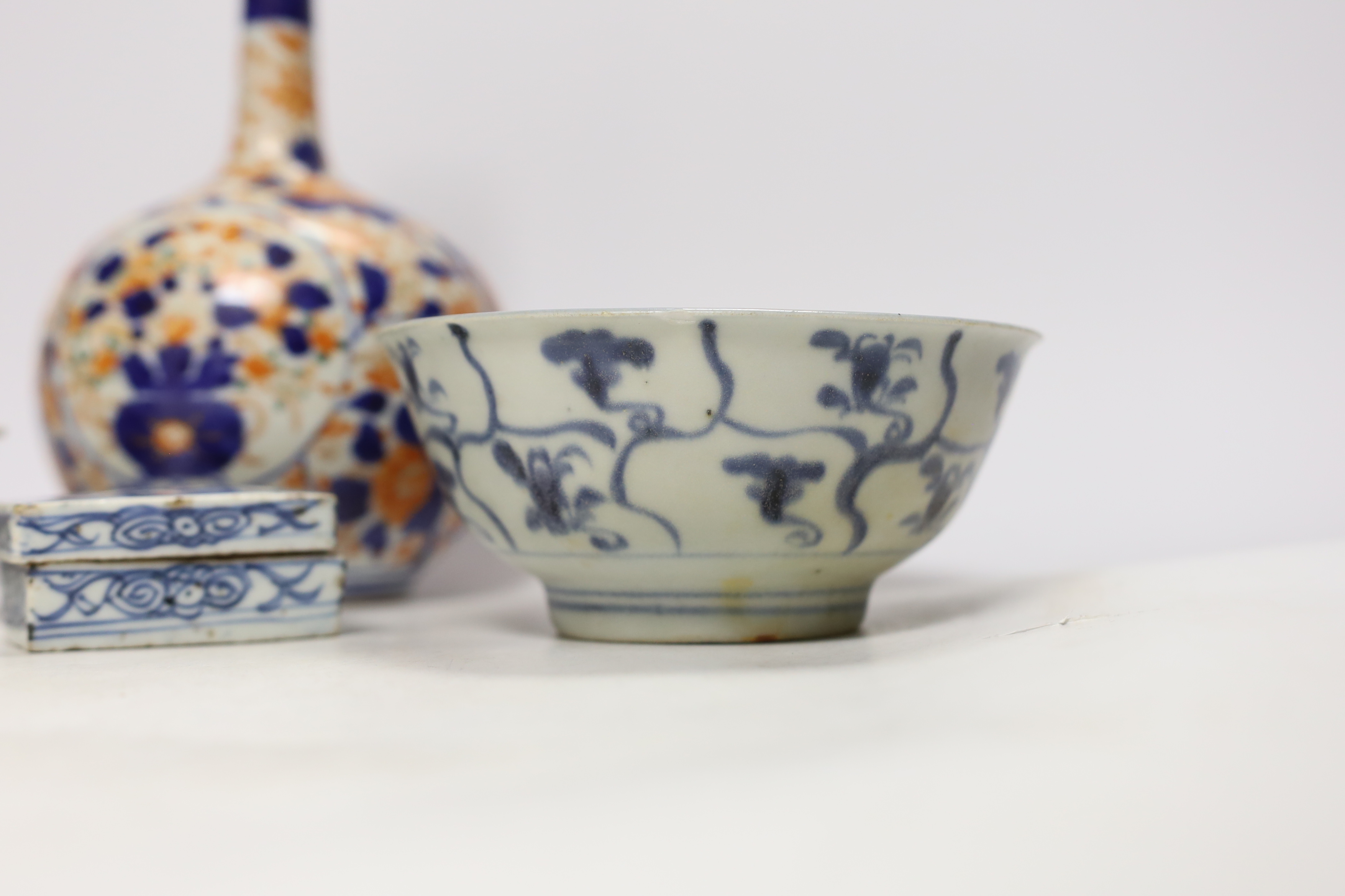 A Chinese Tek Sing Cargo bowl, a Chinese famille Rose Jar and cover, late 19th century, a stem cup with hidden decoration a box and cover and a Japanese Imari bottle vase.